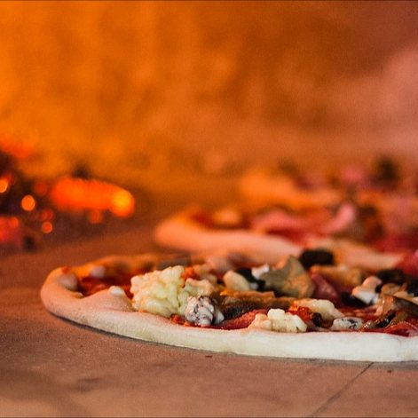Pizza im holzbefeuerten Steinofen