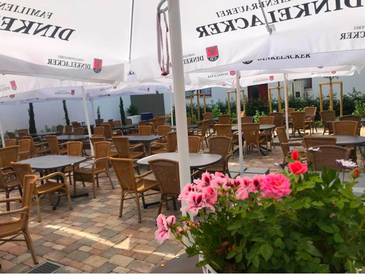 Sommerterrasse mit Blumen und Sonnenschirmen